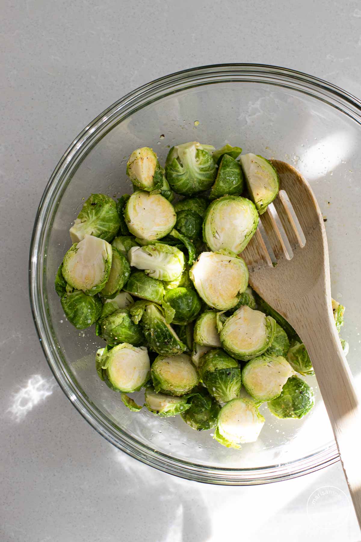 Halved brussels sprouts in a glass bowl.