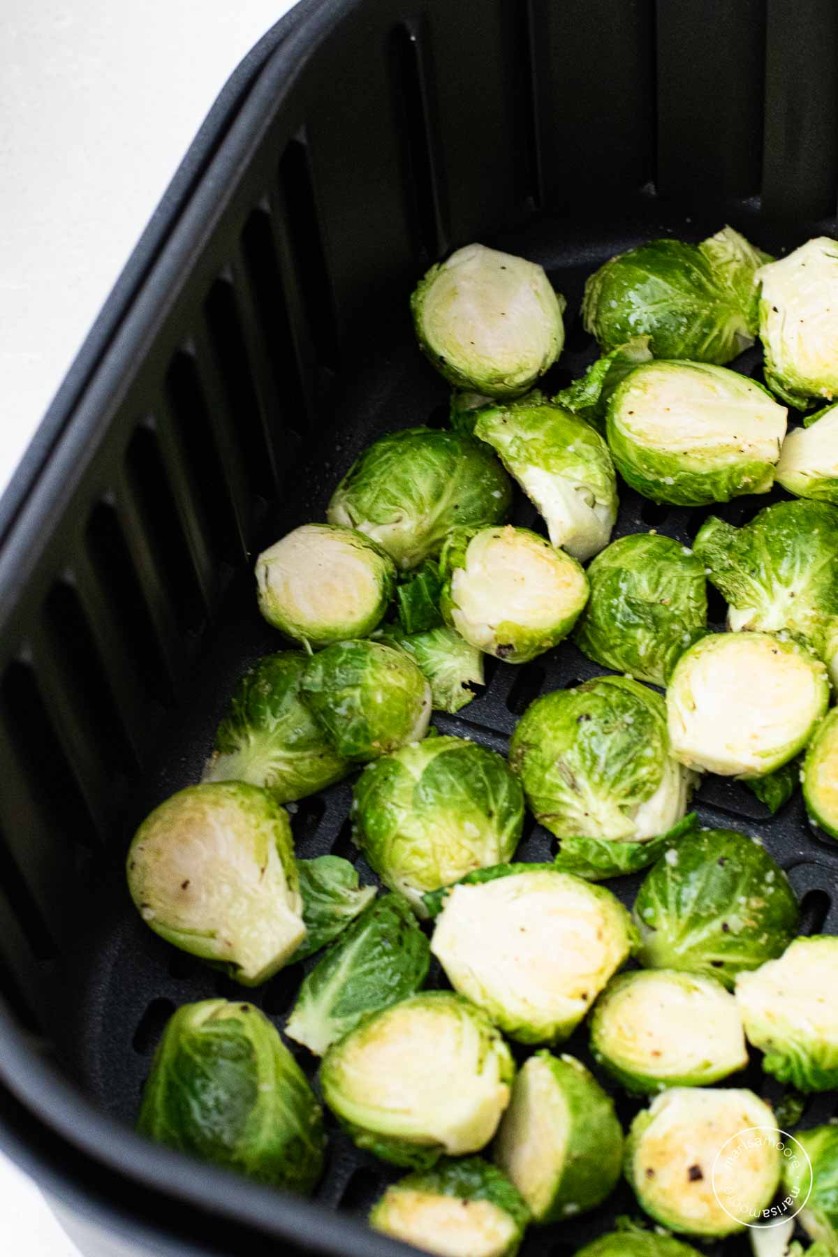 Sliced brussels sprouts in single layer in an air fryer basket
