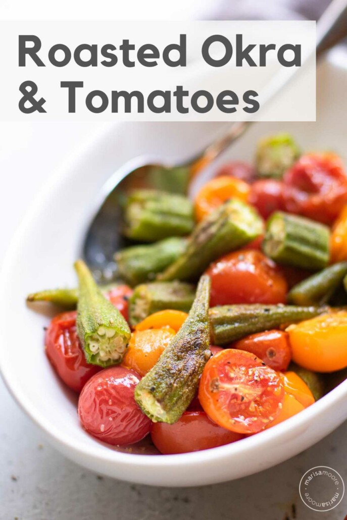 Close up of roasted okra and red and yellow tomatoes in a white serving bowl.